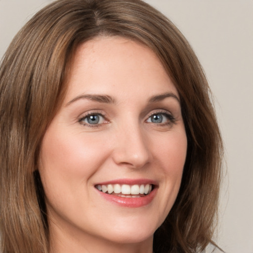 Joyful white young-adult female with long  brown hair and green eyes