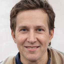 Joyful white adult male with short  brown hair and grey eyes