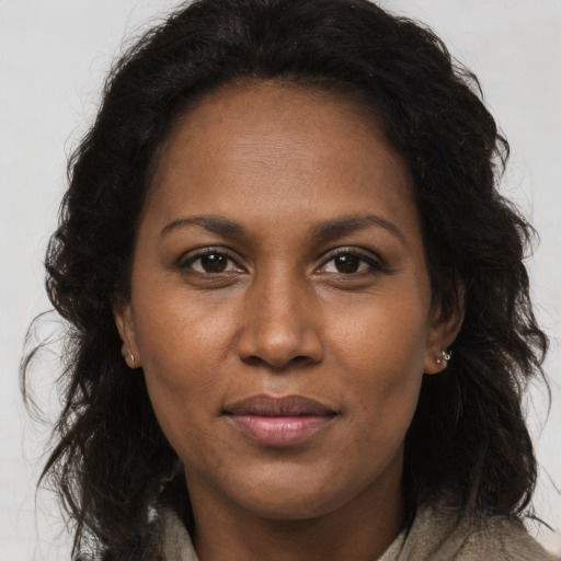 Joyful black young-adult female with long  brown hair and brown eyes