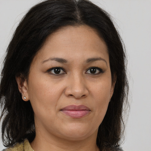 Joyful latino adult female with long  brown hair and brown eyes