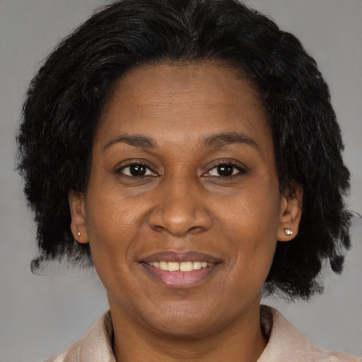 Joyful black adult female with short  brown hair and brown eyes