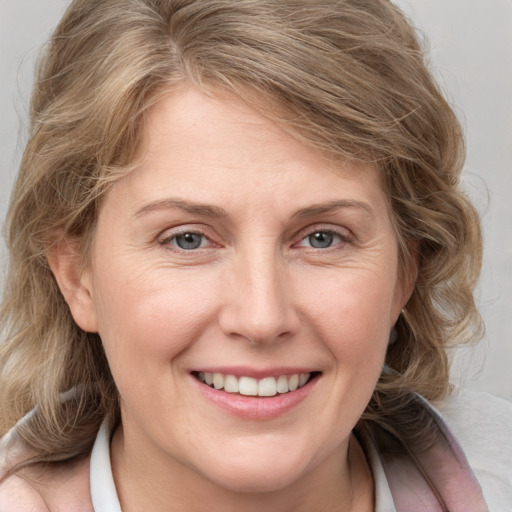 Joyful white adult female with medium  brown hair and blue eyes