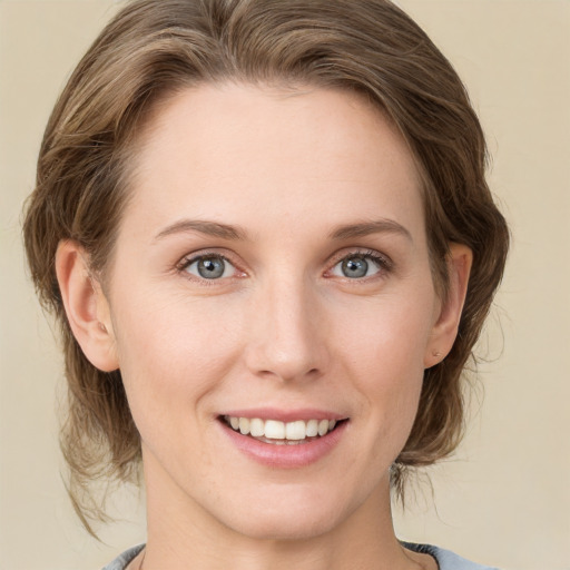 Joyful white young-adult female with medium  brown hair and blue eyes