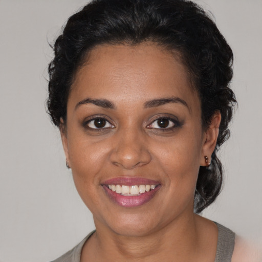 Joyful black young-adult female with short  brown hair and brown eyes