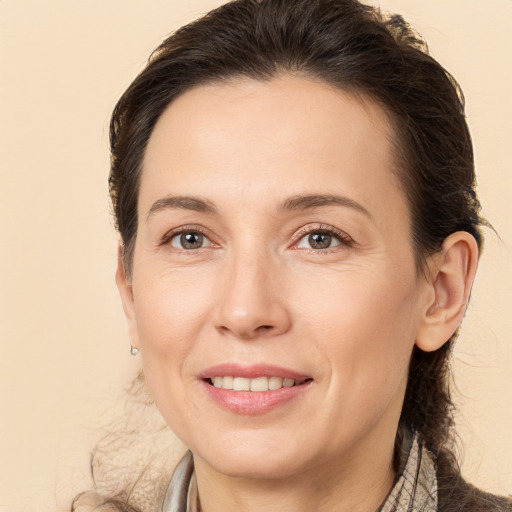 Joyful white adult female with medium  brown hair and brown eyes