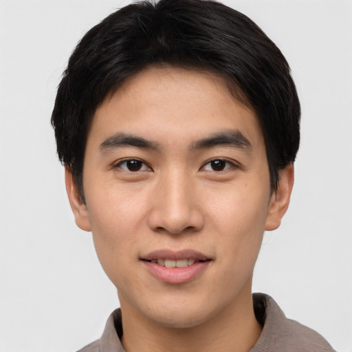 Joyful asian young-adult male with short  brown hair and brown eyes