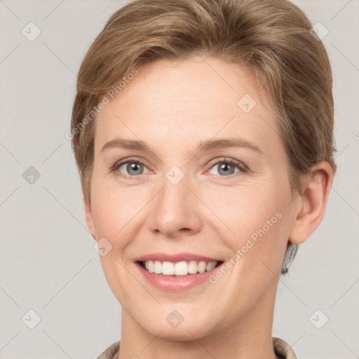 Joyful white young-adult female with short  brown hair and grey eyes