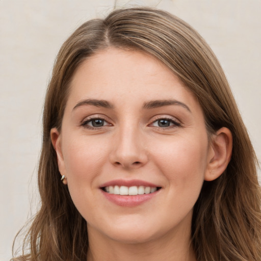 Joyful white young-adult female with long  brown hair and grey eyes