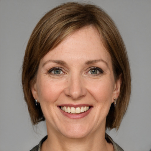 Joyful white adult female with medium  brown hair and grey eyes