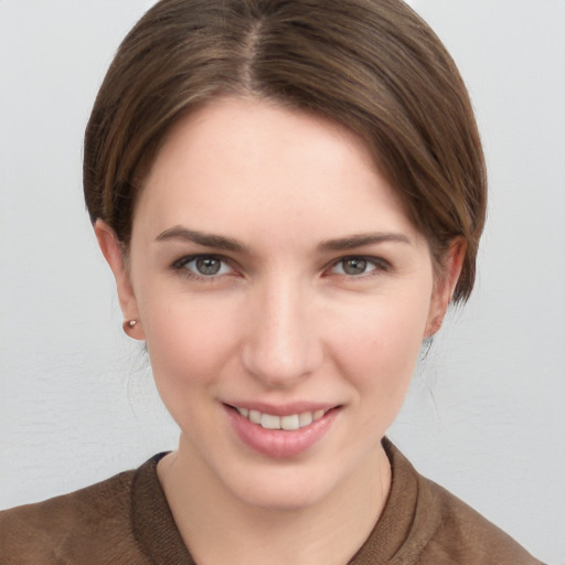 Joyful white young-adult female with medium  brown hair and grey eyes