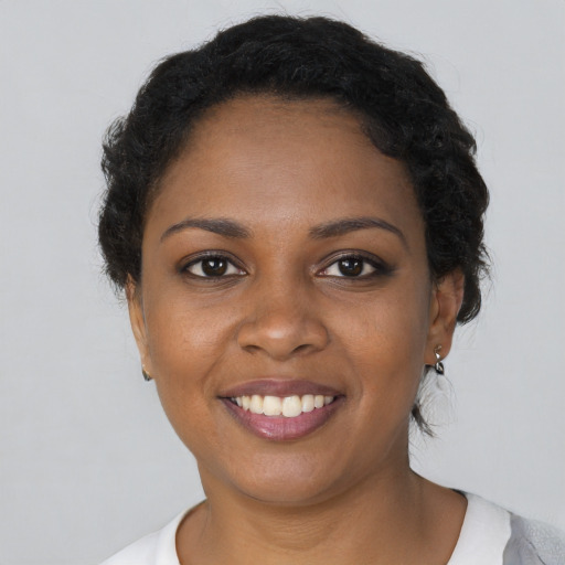 Joyful black young-adult female with short  black hair and brown eyes
