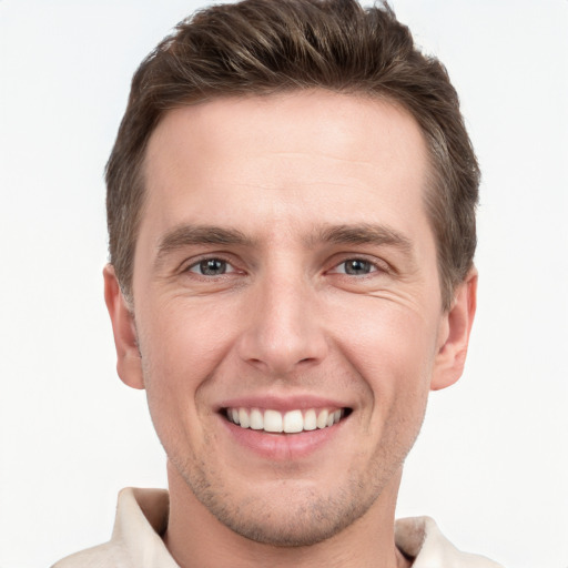 Joyful white young-adult male with short  brown hair and grey eyes