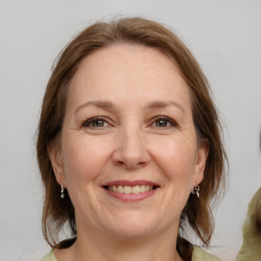 Joyful white adult female with medium  brown hair and grey eyes