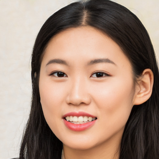 Joyful asian young-adult female with long  brown hair and brown eyes