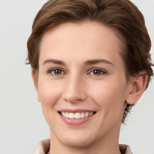 Joyful white young-adult female with short  brown hair and grey eyes