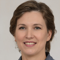 Joyful white adult female with medium  brown hair and grey eyes