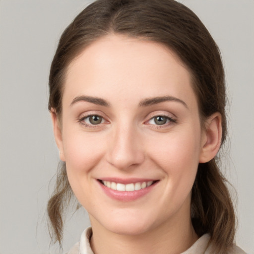 Joyful white young-adult female with medium  brown hair and green eyes