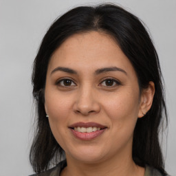 Joyful latino young-adult female with long  brown hair and brown eyes