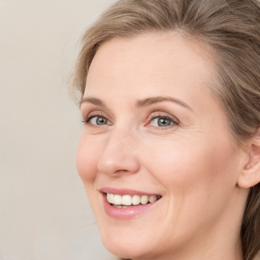 Joyful white young-adult female with medium  brown hair and blue eyes