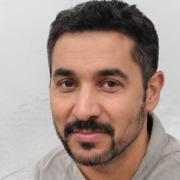 Joyful latino adult male with short  black hair and brown eyes