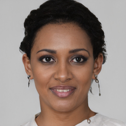 Joyful black young-adult female with short  black hair and brown eyes