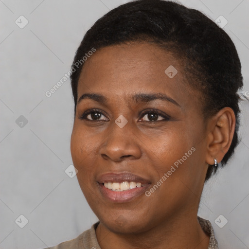 Joyful black young-adult female with short  black hair and brown eyes