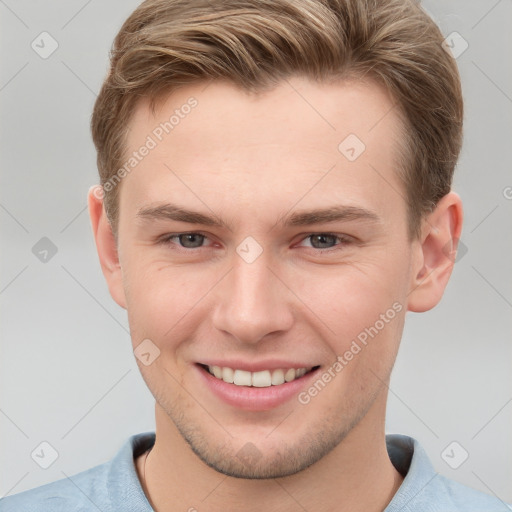 Joyful white young-adult male with short  brown hair and grey eyes