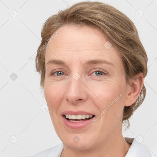 Joyful white adult female with medium  brown hair and grey eyes