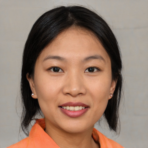 Joyful asian young-adult female with medium  brown hair and brown eyes