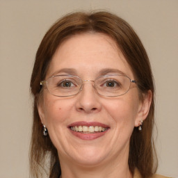 Joyful white adult female with medium  brown hair and blue eyes