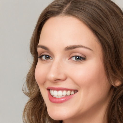 Joyful white young-adult female with long  brown hair and green eyes