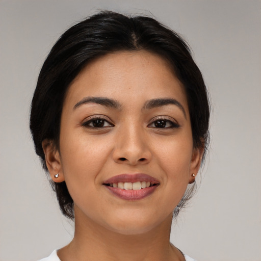 Joyful latino young-adult female with medium  brown hair and brown eyes