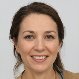 Joyful white adult female with medium  brown hair and grey eyes