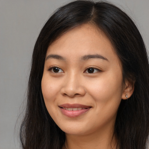 Joyful asian young-adult female with long  brown hair and brown eyes