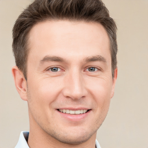 Joyful white young-adult male with short  brown hair and grey eyes