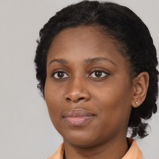 Joyful black young-adult female with short  brown hair and brown eyes