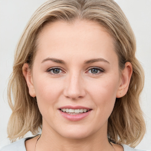 Joyful white young-adult female with medium  brown hair and blue eyes