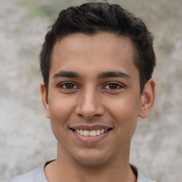 Joyful latino young-adult male with short  brown hair and brown eyes