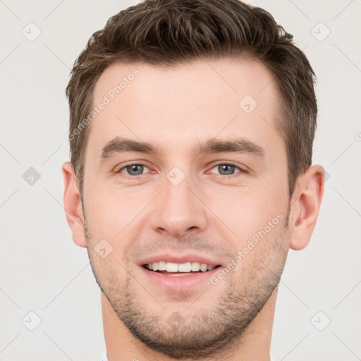 Joyful white young-adult male with short  brown hair and grey eyes