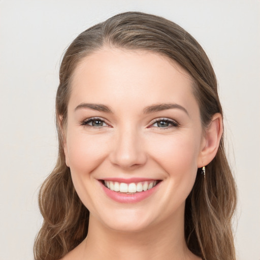 Joyful white young-adult female with long  brown hair and blue eyes