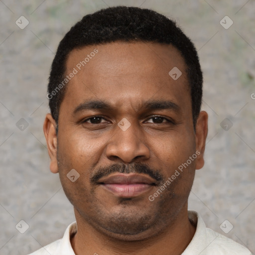 Joyful black young-adult male with short  black hair and brown eyes
