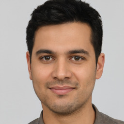 Joyful latino young-adult male with short  black hair and brown eyes