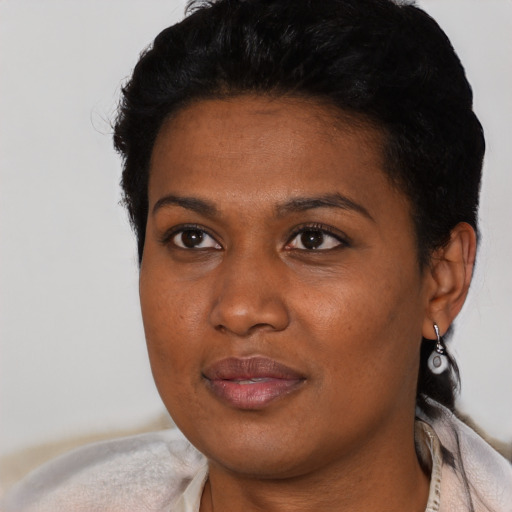 Joyful black young-adult female with short  black hair and brown eyes