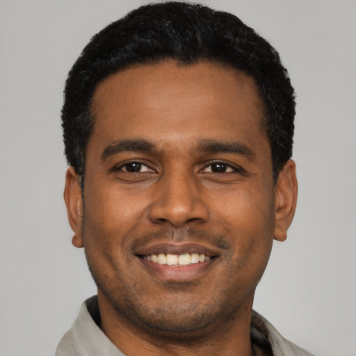 Joyful latino young-adult male with short  black hair and brown eyes