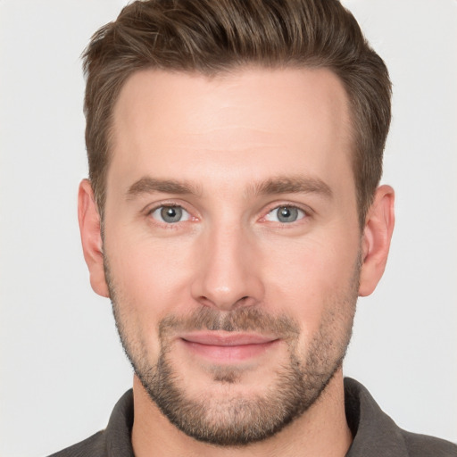 Joyful white young-adult male with short  brown hair and grey eyes