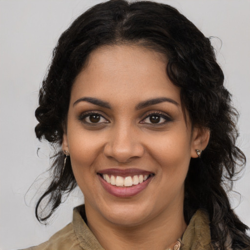 Joyful black young-adult female with long  brown hair and brown eyes