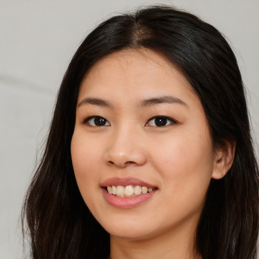 Joyful asian young-adult female with long  brown hair and brown eyes
