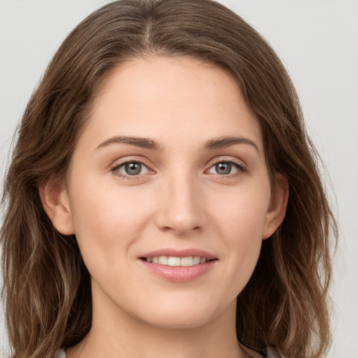 Joyful white young-adult female with long  brown hair and green eyes