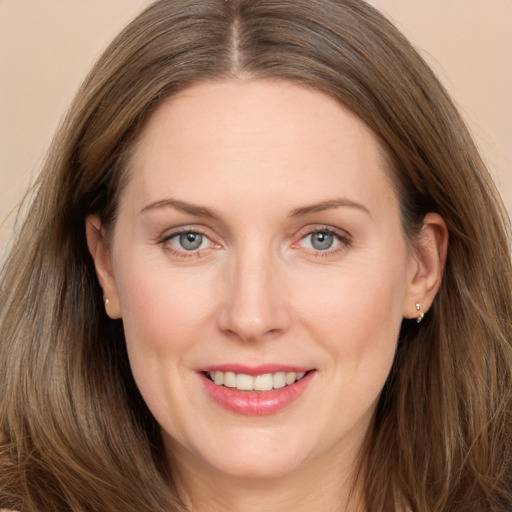 Joyful white adult female with long  brown hair and grey eyes