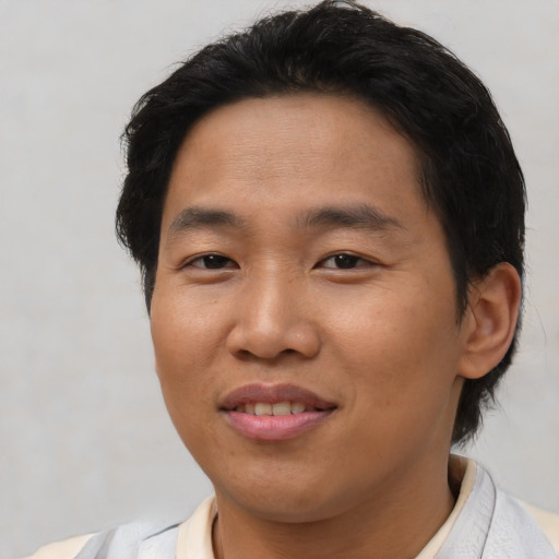Joyful asian young-adult male with short  brown hair and brown eyes